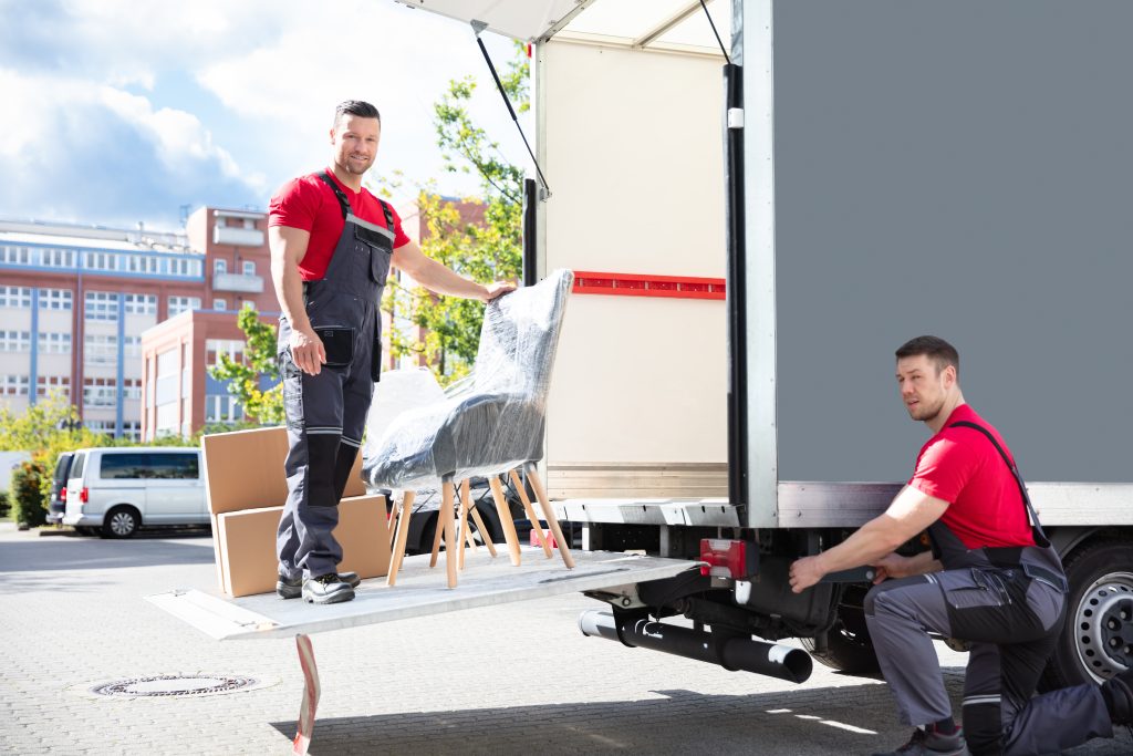 Mitarbeiter von Lünekurier entladen Möbel und Kartons aus einem LKW im Liefergebiet Lübeck